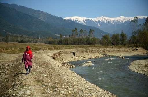 A Kashmiri villager walks past what used to be a pond holding drinking water in Lolab Valley in the foothills of the northern Ka