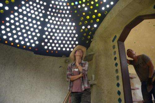 Alexandra Posada (C) pictured with a glass bottle skylight during the building of her house in Choachi, Cundinamarca, Colombia o