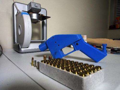 A Liberator pistol appears next to the 3D printer on which its components were made on July 11, 2013