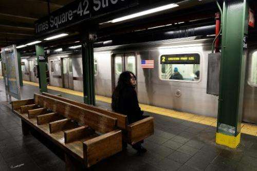 A lonely commuter waits to catch the train at a subway station in New York on January 26, 2015