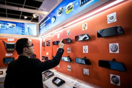 A man browses smart rear mirrors equipped with touch screens at the Hong Kong Electronics Fair in Hong Kong on October 13, 2015