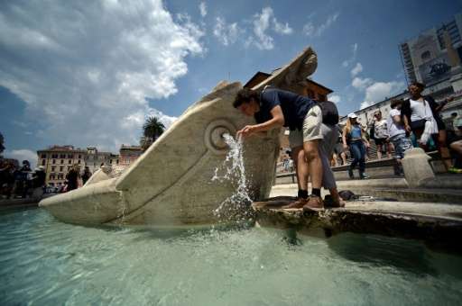 A man drinks fresh water from central Rome's Barcaccia fountain on June 30, 2015, as a major heatwave spreads through Europe