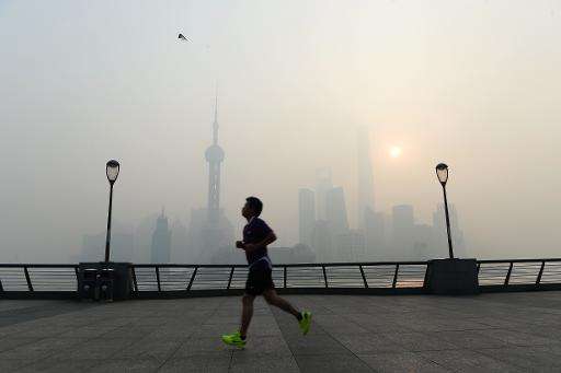 A man exercises amid heavy smog on the Bund in Shanghai on November 12, 2014