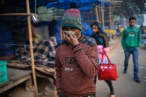 A man in New Delhi covers his face with his handkerchief outside a bus station in the Anand Vihar District