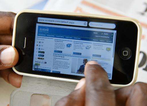 A man looks at a mobile bank website to consult his account on his mobile phone on April 24, 2015 in Abidjan, Ivory Coast