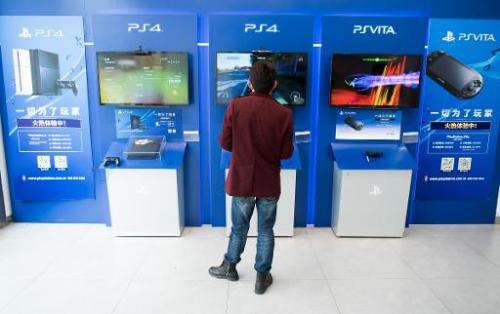A man plays with a Sony PlayStation 4 in a shop in Shanghai, March 19, 2015