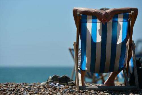 A man relaxes on a deckchair on the beach in Brighton during hot weather on the southern English coast on August 1, 2013