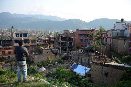 A man stands near collapsed houses in Bhaktapur, on the outskirts of Kathmandu, on April 27, 2015, two days after a 7.8 magnitud