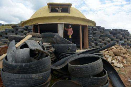 A man works building a house with tires in Choachi, Colombia on March 16, 2015