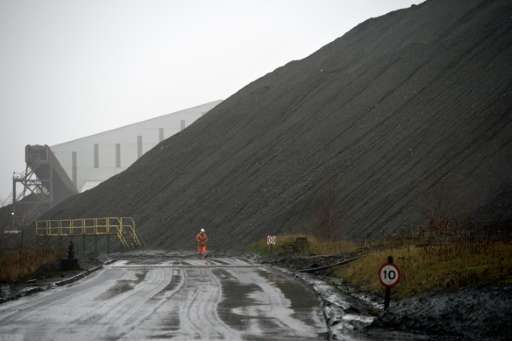 A mine worker walks past a slag heap at the entrance to Kellingley Colliery, the last deep coal mine operating in Britain near K