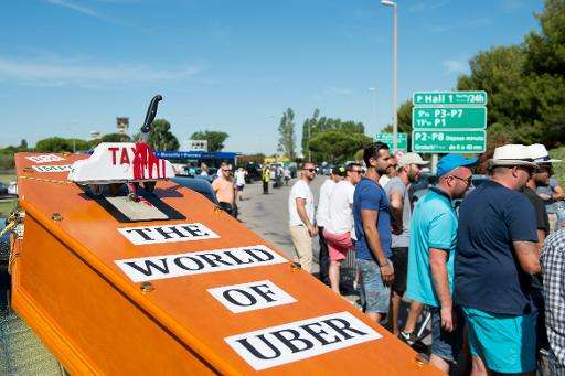 A mock coffin is displayed by striking taxi drivers as they  block access to the  Marignane airport near Marseille, southern Fra