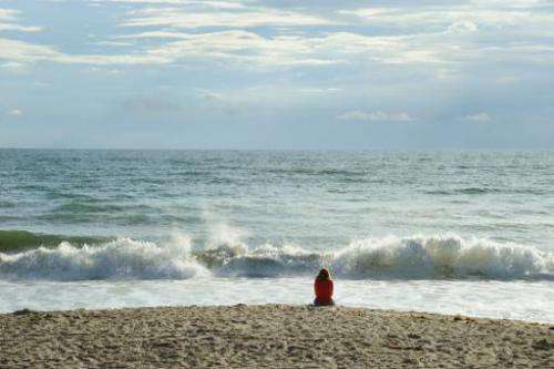An early morning beach goer looks out over the Atlantic Ocean on September 11, 2009 near the Kennedy Space Center in Florida
