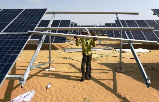 An engineer installs a solar panel at the under-construction Roha Dyechem solar plant in Bhadla, some 225 km north of Jodhpur, i