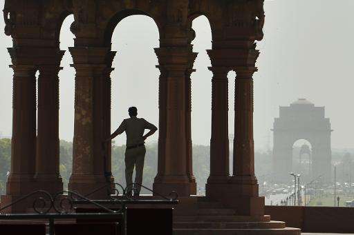 An Indian policeman stands in the shade at the Indian Defence Ministry in New Delhi on May 26, 2015