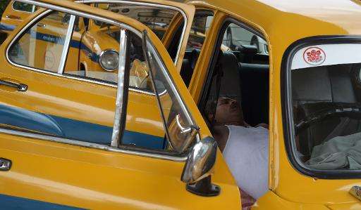 An Indian taxi driver rests in his parked car in Kolkata on May 25, 2015