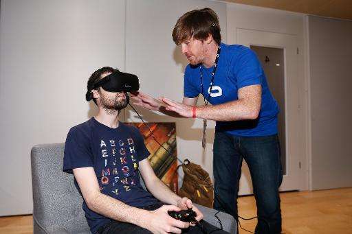An Oculus emplyoee helps set up the virtual reality head-mounted display Oculus Rift CV1 on a gamer, at the Annual Gaming Indust