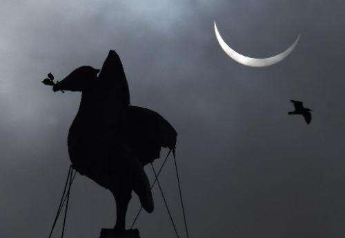 A partial solar eclipse is visible next to the iconic Liver Bird on top of the Liver Building in Liverpool, north-west England o
