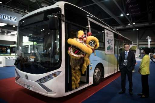 A performer wearing a lion dance costume stands in the door of an electric bus during the opening of the China International New