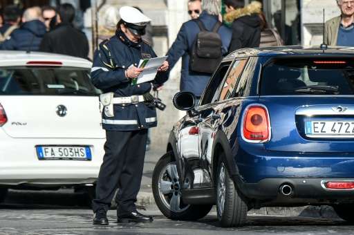 A police officer controls cars and scooters during the limited traffic day in centeral Rome on December 29, 2015