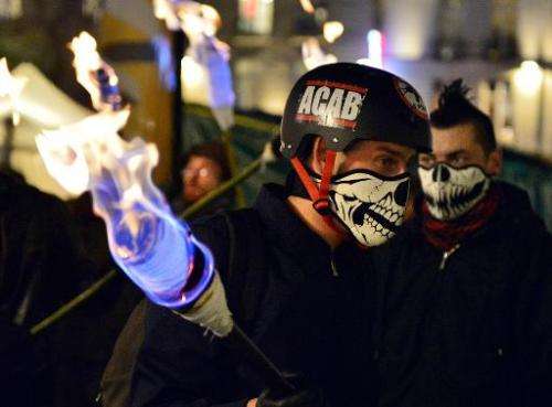 A protestor holds a torch on December 5, 2014 in Nantes during a protest against police brutality following the death of 21-year