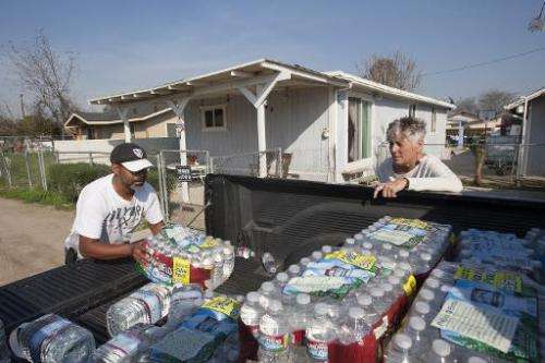 A resident of East Porterville, California, receives a delivery of drinking water as water wells supplying hundreds of residents