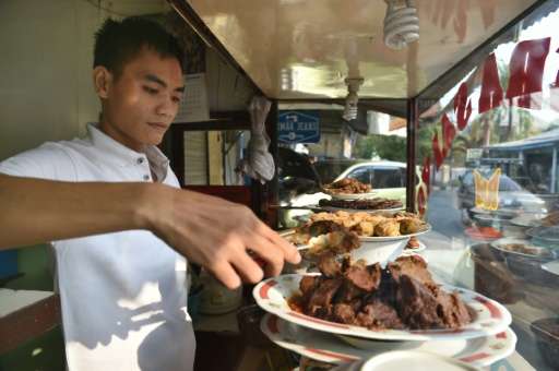 A restaurant employee in Jakarta prepares rendang, a traditional West Sumatranese meat dish