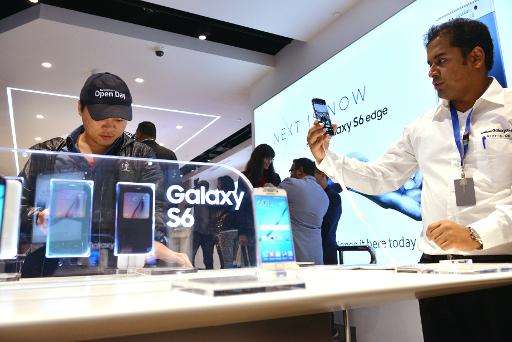 A sales representative shows customers the new Samsung Galaxy S6 and S6 Edge in a store in Sydney on April 10, 2015
