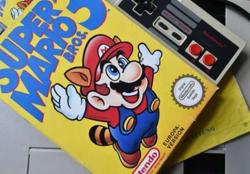 A 'Super Mario 3' game is seen on top of a 1980's NES games console, in Berlin