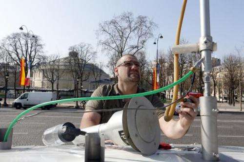 A technician sets up apparatus on a mobile pollution level-checking station on the Avenue des Champs Elysees in Paris on March 2