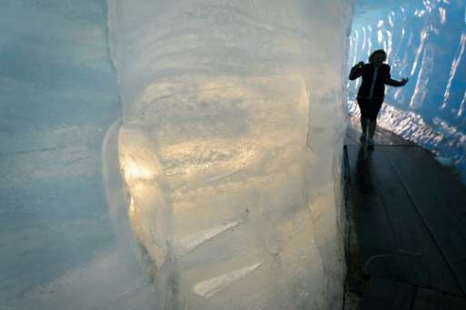 A tourist visits an ice cave inside the Rhone Glacier, which has retreated about 40 metres in length due to melting in the past 
