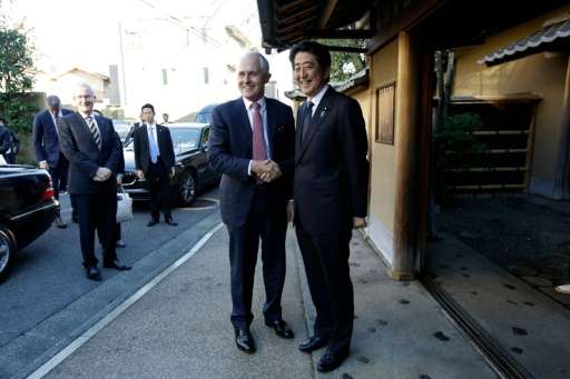 Australian PM Malcolm Turnbull (L) and Japanese PM Shinzo Abe (R) shake hands prior to a tea ceremony hosted Sen Soshitsu, the G