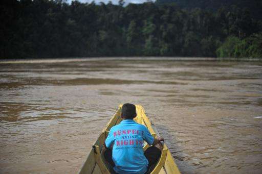 A villager sits inside a boat near the proposed dam on the Baram River in Tanjung Tepalit, in Malaysia's Sarawak state on the is