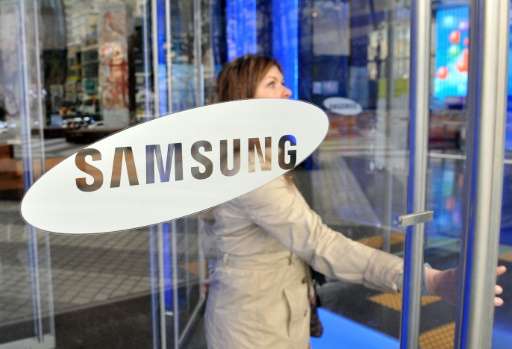 A visitor walks past a logo of Samsung Electronics at the company's headquarters in Seoul on November 22, 2013