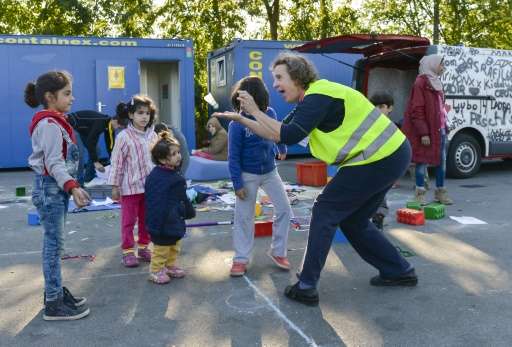 A volunteer plays with children play at a refugee camp close to border between Austria and Germany in the Austrian city of Salzb
