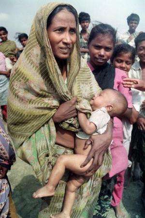 A woman carries her baby in Banskhali, Chittagong district, on May 9, 1991 in the aftermath of Bangladesh's worst cyclone in 20 