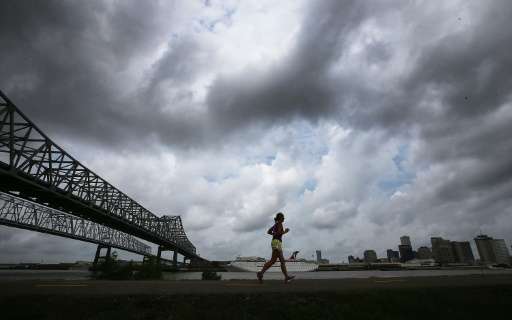A woman jogs along a levee along the Mississippi River with the city skyline in the distance on May 16, 2015 in New Orleans, Lou