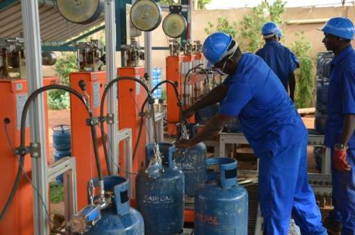 A worker fills a bottle with Butane gas at a gas factory in Niamey on July 20, 2015