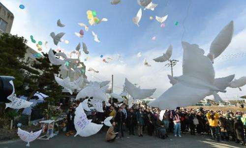 Balloons in the shape of doves are released into the air during a memorial service for the victims of the 2011 quake-tsunami dis