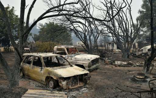 Burned vehicles sit on a property charred by the Valley fire in Middletown, California on September 13, 2015