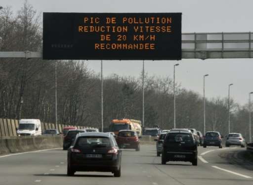 Cars pass under a sign reading &quot;Pollution peak, reduce speed by 20 km/h&quot; on Lille's beltway on April 8, 2015