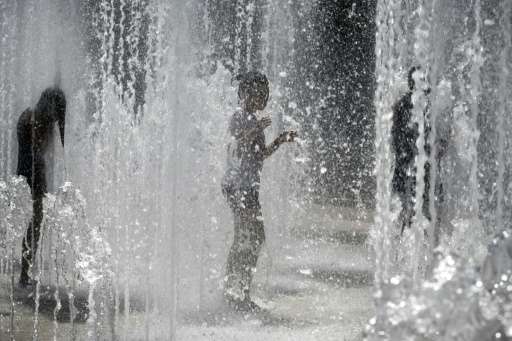 Children cool off in a fountain in Lyon, France, on June 30, 2015, as a major heatwave spreads up through Europe