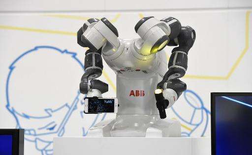 Collaborative dual-arm robot YuMi holds a smartphone and a torch at the Swiss automation group ABB booth at the Hannover Messe i