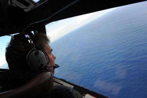 Co-pilot Brett McKenzie helps to look for objects during the search for missing Malaysia Airlines flight MH370, from a Royal New