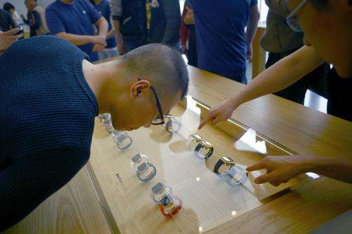 Customers look at the new Apple Watch at an Apple store in Beijing on April 10,2015