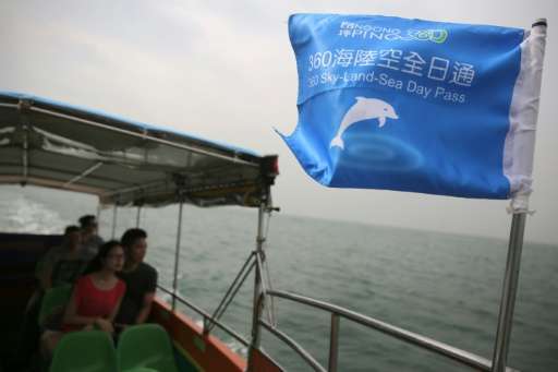 Customers on a boat tour to see the famous pink dolphins around the waters of Tai O in Hong Kong