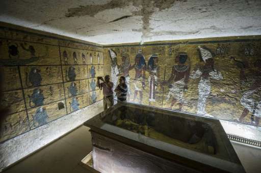 Egyptian archaeologists take pictures next to the sarcophagus of King Tutankhamun in his burial chamber in the Valley of the Kin