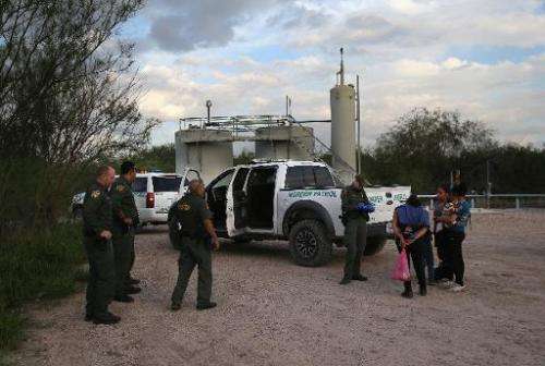 Families of Central American immigrants turn themselves in to US Border Patrol agents after crossing the Rio Grande River from M