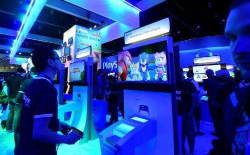 Fans play games at Sony booth during the annual E3 video game extravaganza in Los Angeles, California, on June 10, 2014