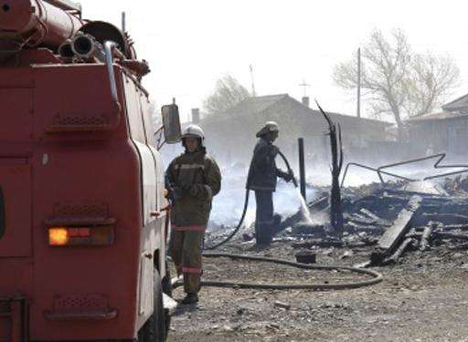 Firefighters extinguish a fire in a village in the Khakassia region of Siberia on April 12, 2015