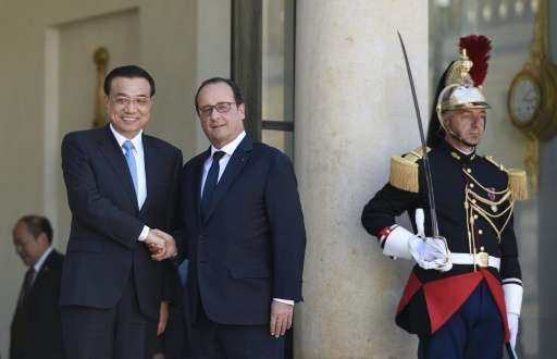French President Francois Hollande (R) and Chinese Prime minister Li Keqiang shake hands at the Elysee palace, on June 30, 2015,